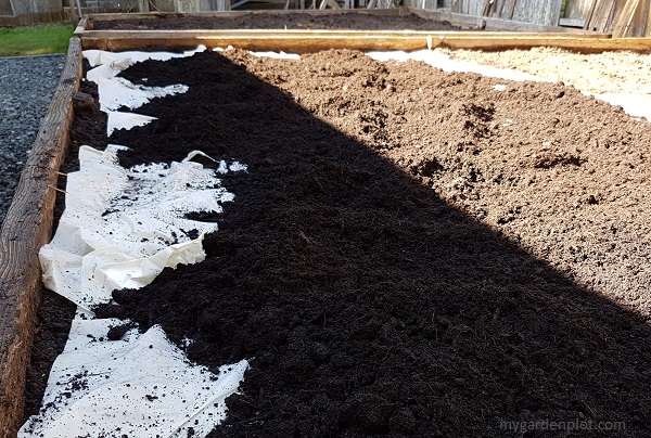 Adding compost over wet paper mulch (photo by My Garden Plot)